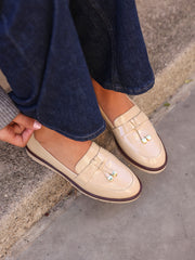 Model wearing Nancy mocha patent tassel loafers